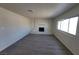 Living room featuring wood-look floors, bright window, and cozy painted brick fireplace at 3749 Ponderosa Ave, Las Vegas, NV 89115
