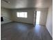 Spacious living room with wood-look flooring, bright window, and convenient exterior access at 3749 Ponderosa Ave, Las Vegas, NV 89115