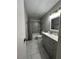 Bathroom featuring gray cabinets, single sink, and a shower with gray tile at 3813 Marshall Cir, Las Vegas, NV 89108