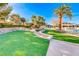 Serene backyard space with lush green turf, palm trees, and elegant landscaping at 4 Annadale Ct, Henderson, NV 89052