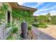 Beautiful landscaped backyard with a water fountain feature, stone pathway, and vibrant green plants and vines at 4 Annadale Ct, Henderson, NV 89052