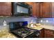 Well-equipped kitchen with granite counters, a modern gas range, and dark wood cabinetry, offering a stylish and practical design at 4610 Lime Straight Dr, Las Vegas, NV 89115