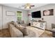 Cozy living area showcasing a comfortable grey sectional sofa and a stylish media console beneath a wall-mounted television at 4610 Lime Straight Dr, Las Vegas, NV 89115
