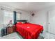 Bright bedroom featuring a cozy bed with a red comforter and a matching bedside table at 4870 E Colorado Ave, Las Vegas, NV 89104