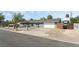 Inviting single-story home with an attached garage, a long driveway, and a low-maintenance gravel yard at 4870 E Colorado Ave, Las Vegas, NV 89104