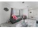 Cozy living area featuring marble floors, a large window with curtains, and a comfortable gray couch at 4870 E Colorado Ave, Las Vegas, NV 89104
