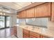 Kitchen featuring oak cabinets, a white dishwasher, a double sink, and an opening to the adjacent living area at 5068 Jeffreys St # 202, Las Vegas, NV 89119