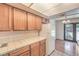 Well-lit kitchen with tile countertops, oak cabinets, white appliances, and an adjacent dining area with outdoor access at 5068 Jeffreys St # 202, Las Vegas, NV 89119