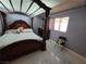 Ornate four-poster bed with detailed carvings and neutral-toned bedding in a well-lit room at 5594 Ricochet Ave, Las Vegas, NV 89110