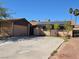 Single-story home with a two car garage, solar panels, and a spacious driveway on a sunny day at 5594 Ricochet Ave, Las Vegas, NV 89110