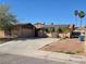 Single-story home with a two car garage, solar panels, and a spacious driveway on a sunny day at 5594 Ricochet Ave, Las Vegas, NV 89110
