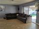 Cozy living room featuring neutral tile flooring, a sectional sofa and sliding glass door leading to patio at 5594 Ricochet Ave, Las Vegas, NV 89110