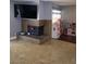 Cozy living room featuring neutral tile flooring, a brick fireplace, and a large screen TV at 5594 Ricochet Ave, Las Vegas, NV 89110