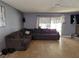 Cozy living room featuring neutral tile flooring, a sectional sofa and sliding glass door leading to patio at 5594 Ricochet Ave, Las Vegas, NV 89110