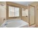 Bright bathroom featuring a bathtub, shower, and frosted glass door at 6131 Cozy Creek St, North Las Vegas, NV 89031