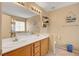 Well-lit bathroom featuring double sinks, a bathtub, and storage at 6131 Cozy Creek St, North Las Vegas, NV 89031