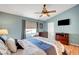 Comfortable bedroom with a ceiling fan, a TV, and wood-look flooring at 6131 Cozy Creek St, North Las Vegas, NV 89031