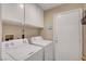 Laundry room featuring white washer and dryer units, storage cabinets and an external door at 6131 Cozy Creek St, North Las Vegas, NV 89031