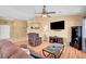 Bright living room features a fireplace, TV, ceiling fan, and a comfy armchair at 6131 Cozy Creek St, North Las Vegas, NV 89031