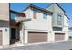 Modern townhome exterior with private garage and neutral color scheme on a sunny day at 6145 May River St, Las Vegas, NV 89148