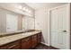 Bathroom with granite countertops, wood cabinets, and a large mirror over the vanity at 647 Foxhall Rd, Henderson, NV 89002