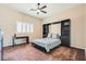 Bedroom featuring a murphy bed with shelving, desk and ceiling fan with a window at 647 Foxhall Rd, Henderson, NV 89002
