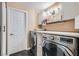 Laundry room with new appliances, light cabinets, and dark floors at 647 Foxhall Rd, Henderson, NV 89002