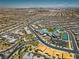 A sweeping aerial view of a community featuring mature landscaping, tennis courts, and a large community center at 6700 Regency Stone Way, Las Vegas, NV 89148