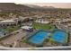 Aerial view of community clubhouse with pool, tennis courts, and walking paths surrounded by mature landscaping at 6700 Regency Stone Way, Las Vegas, NV 89148