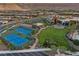 An aerial view of community tennis and pickelball courts next to a community pool and clubhouse at 6700 Regency Stone Way, Las Vegas, NV 89148