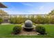 Landscaped backyard showcasing a unique water feature and manicured shrubbery at 6700 Regency Stone Way, Las Vegas, NV 89148