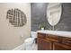 Stylish half-bath with modern vanity, decorative mirror and accent wall at 6700 Regency Stone Way, Las Vegas, NV 89148