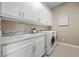 Modern laundry room with white cabinets, marble countertop, and new washer/dryer units at 6700 Regency Stone Way, Las Vegas, NV 89148