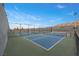 Outdoor community tennis courts with blue playing surface surrounded by a dark fence and mature community landscaping at 6700 Regency Stone Way, Las Vegas, NV 89148