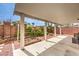 An inviting backyard with a covered patio area, lush greenery, and well-maintained garden beds at 6843 Philharmonic Ave, Las Vegas, NV 89139
