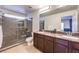 Modern bathroom with double vanity, granite countertop, and tiled shower with glass doors at 6843 Philharmonic Ave, Las Vegas, NV 89139