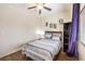 Well-lit bedroom with bed, ceiling fan, window with blinds, and decorative wall art at 6843 Philharmonic Ave, Las Vegas, NV 89139