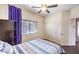 Bedroom featuring a comfortable bed, purple curtains, and a window with blinds at 6843 Philharmonic Ave, Las Vegas, NV 89139