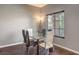 A modern dining room features a glass table, wood floors, and a large window with blinds at 6843 Philharmonic Ave, Las Vegas, NV 89139