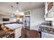 Open-concept kitchen with stainless steel appliances, a granite-topped island, and access to the living area at 6843 Philharmonic Ave, Las Vegas, NV 89139