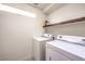 Functional laundry room featuring modern appliances and a shelf for storage at 6843 Philharmonic Ave, Las Vegas, NV 89139