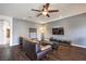 Inviting living room with dark wood floors, a ceiling fan, and a comfortable brown leather sofa at 6843 Philharmonic Ave, Las Vegas, NV 89139