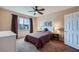 Cozy bedroom featuring neutral walls, brown carpeting, a ceiling fan, and a window with brown curtains offering a view at 7151 S Durango Dr # 312, Las Vegas, NV 89113