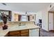 The kitchen features wood cabinets, white countertops and a double sink; an open layout allows natural light from large windows to flood the space at 7151 S Durango Dr # 312, Las Vegas, NV 89113