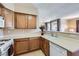 A cozy kitchen features wooden cabinetry, white countertops, and modern appliances including a gas range and a built-in microwave at 7151 S Durango Dr # 312, Las Vegas, NV 89113