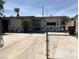 Single-story home featuring stone accents, a secure gated entry and a spacious driveway for multiple vehicles at 725 Miller Ave, North Las Vegas, NV 89030
