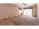 Large main bedroom featuring neutral carpeting, ceiling fan, and a sliding glass door with a view to backyard at 7824 Pine Warbler Way, North Las Vegas, NV 89084