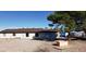 A large lot with a home that has a brown roof and a blue container in the far background at 7990 Firethorn, Las Vegas, NV 89123