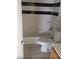 Bathroom with white tile, toilet, and tub with tile surround at 7990 Firethorn, Las Vegas, NV 89123