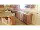 A bright kitchen that includes an island, tiled floors, wood cabinetry, and modern appliances at 7990 Firethorn, Las Vegas, NV 89123